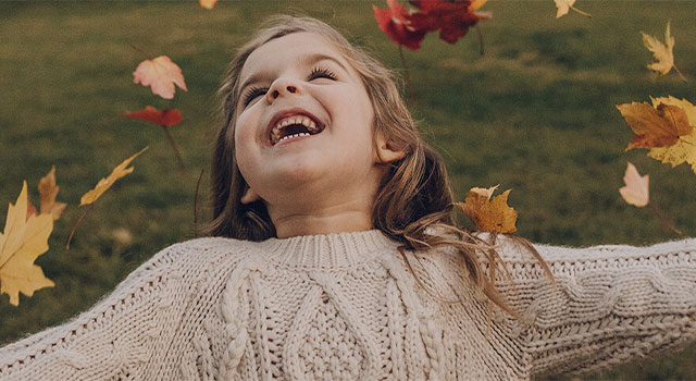 Girl with Childhood Glaucoma Playing in the Leaves