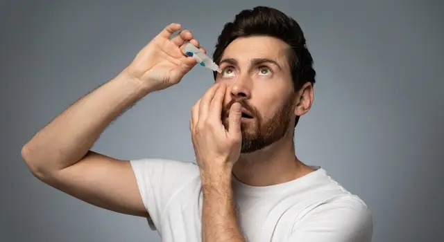 man applying eye drops for dry eyes